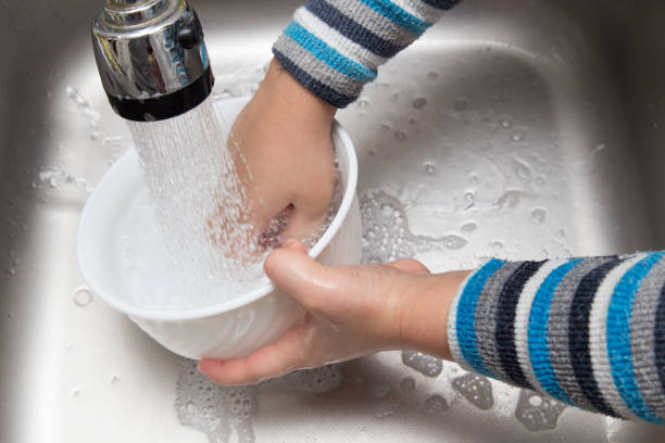 istock boy washing dishes in the kitchen 897889930