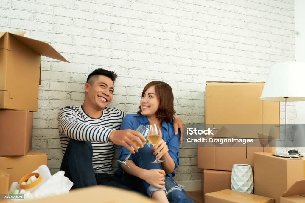 Dreaming young couple Young couple drinking wine and discussing their dreams in new apartment Adult Stock Photo