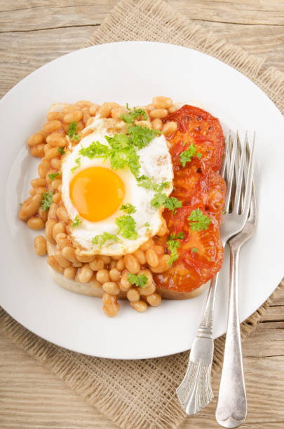istock fried egg with grilled tomato slices and baked beans 897895570