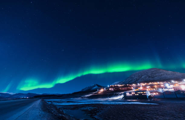 der arktische polare nordlicht aurora borealis himmel sterne in norwegen spitzbergen in longyearbyen stadt mond berge - insel spitzbergen stock-fotos und bilder