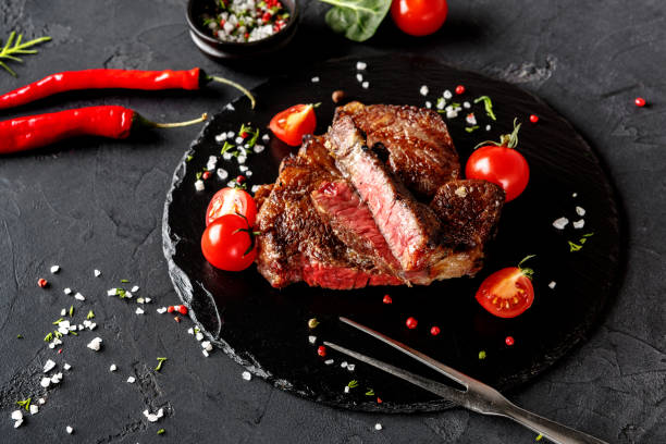 istock Rare rib eye steak on dark plate, closeup 897937036