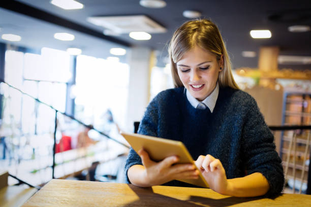 istock Happy young woman using tablet at coffee shop 897937388