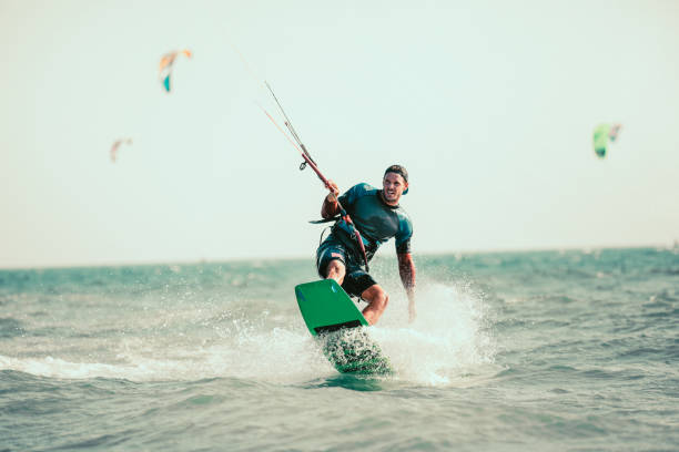 Man kiteboarding on choppy waves Kitesurfing Kiteboarding action photos man among waves quickly goes kiteboarding stock pictures, royalty-free photos & images