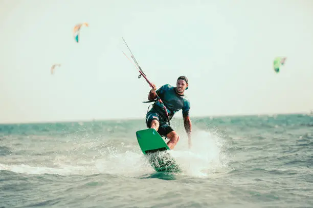 Photo of Man kiteboarding on choppy waves