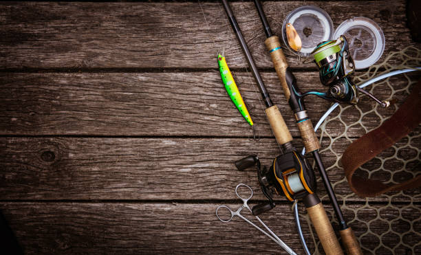 Fishing tackle background. Fishing design elements. Fishing accessories on the wooden table. Elements for advertising fishing rod stock pictures, royalty-free photos & images