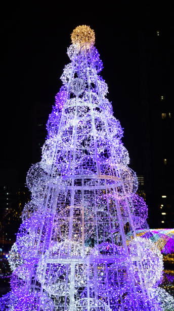 istock Brilliant Christmas tree decorated with courful bright light bulb in dark night 897963236