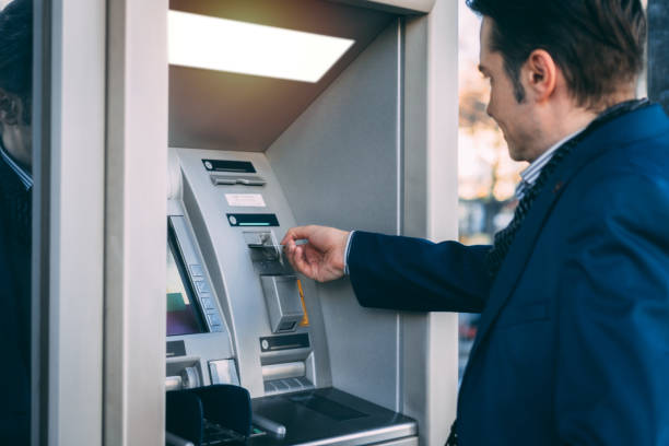 istock Businessman using cash machine and withdrawing money. 897966264