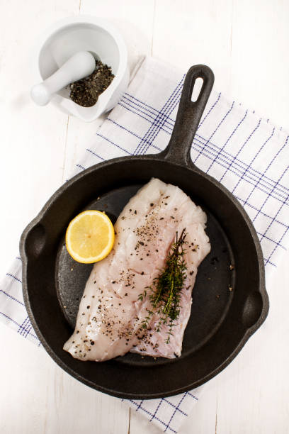 istock raw hake fillet with thyme and a lemon slice 897966646