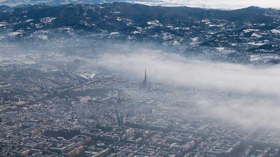 Turin aerial view. Torino cityscape from above, Italy. Winter, fog and clouds on the skylline. Smog and air pollution.