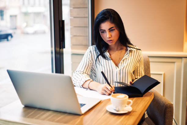 istock Young charming pensive entrepreneur checking accounting balance while transferring money via online banking service.Pretty female blogger reading interesting news and writing down information 897969746