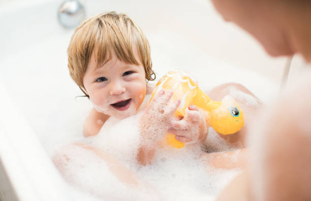 istock Baby Boy Playing in Bathtub With Parent 897972536