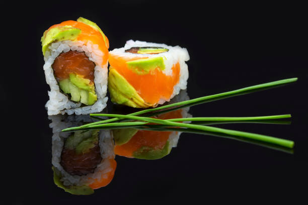 istock Sushi arranged on a shiny black surface looking very delicious 897972602