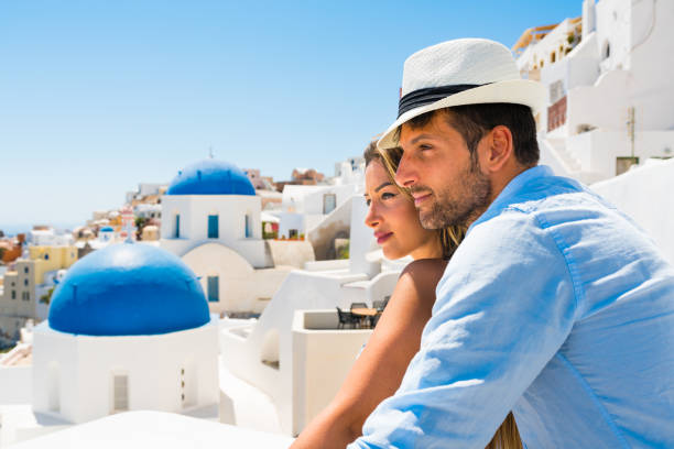 Happy young couple enjoying view on caldera from village Oia (Ia) on Santorini island, Greece. Check for my similar photos from same series. Photo taken by Sony a7R II, 42 Mpix.