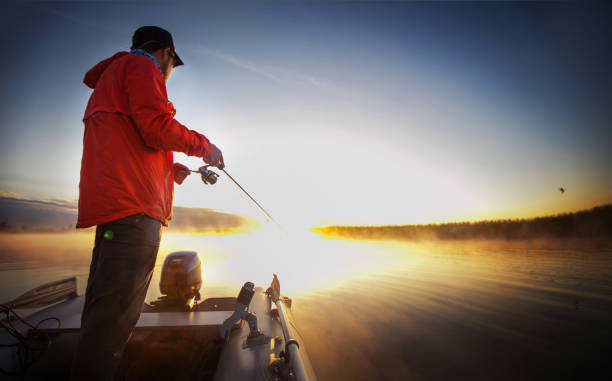 pêche du coucher du soleil. l’homme pêche sur un lac. - lure loc photos et images de collection