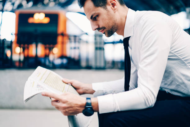 cropped image of successful lawyer dressed in stylish formal wear reading latest news in financial column of morning newspaper.side view of bankir with wristwatch searching information in mass media - newspaper the media paper blank imagens e fotografias de stock