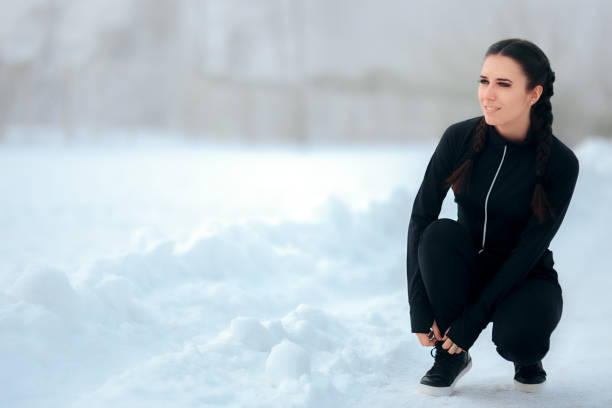istock Winter Female Runner Resting in Between Cardio Sessions Tying her Shoes 897980178