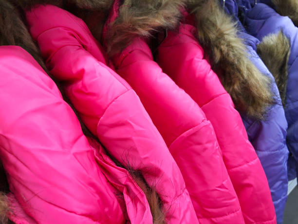 istock Men's and women's down jackets on the counter in the store 897983390