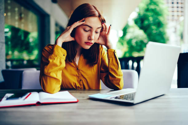 istock Beautiful skilled female graphic designer deeply thinking while distantly working on laptop computer connected to 4G.Tired redhead woman making remote job while sitting at wooden table outdoors 897988048