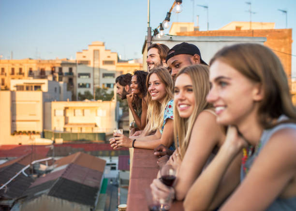 istock Young diverse group of people on rooftop terrace watching dusk 897997860