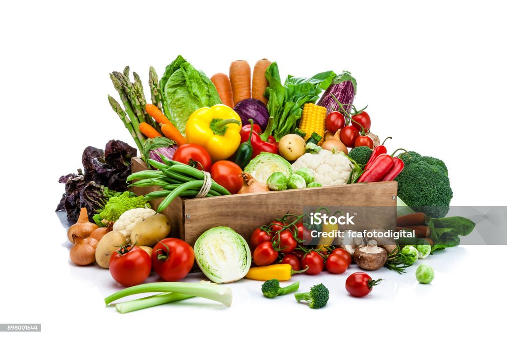 Healthy fresh vegetables in a wooden crate isolated on white background Front view of healthy fresh vegetables in a wooden crate isolated on white background. Some vegetables are out the crate placed directly on the table. Vegetables included in the composition are lettuce, bell pepper, onion, cucumber, eggplant, cauliflower, broccoli, tomato, edible mushroom, carrot, cabbage, corn and others. DSRL studio photo taken with Canon EOS 5D Mk II and Canon EF 70-200mm f/2.8L IS II USM Telephoto Zoom Lens Vegetable Stock Photo