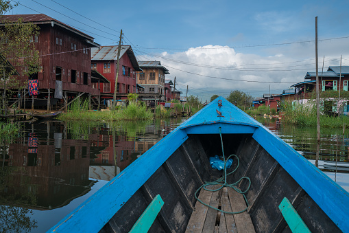 Point of view from longtail boat on Inle lake cruising between houses and temples. Nyaung Shwe, Myanmar, Asia.