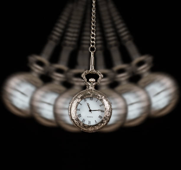 istock Pocket watch silver swinging on a chain black background to hypnotize 898014124