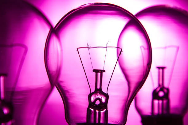 istock Row of light bulbs on a bright pink background with detail 898014344