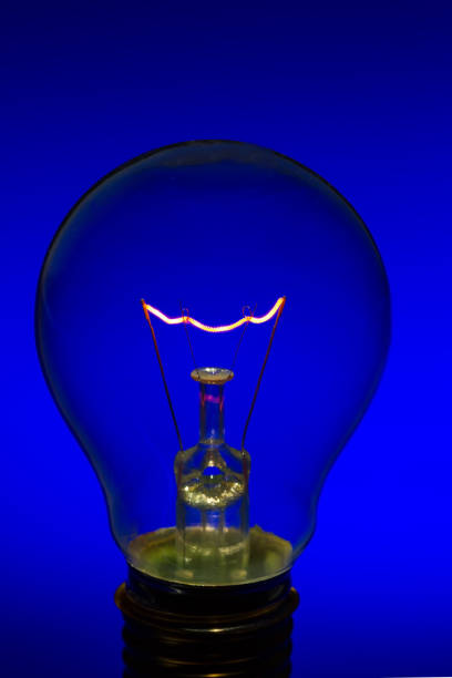 A compact fluorescent light bulb emits a soft blue glow, showcasing its unique swirl design. The lighting creates an artistic ambiance, enhancing the overall atmosphere in the room.