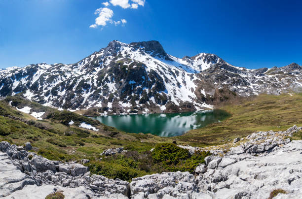 portrait of a young woman sitting on the rocks on the shore of one of the lakes of covadonga (asturias,Spain) with space for copy.