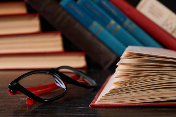 istock Closeup of reading glasses with book 898018990