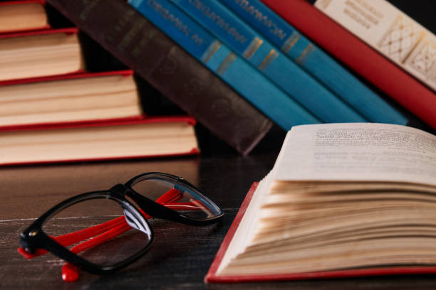 istock Closeup of reading glasses with book 898019068