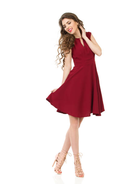 Happy Young Woman Is Posing In Red Dress And High Heels stock photo