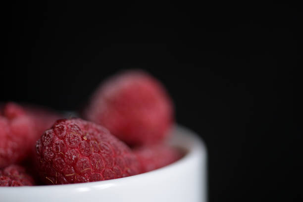 Frozen berries of raspberries on a dark background close up
