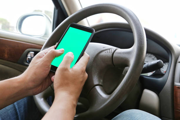 Man Using his mobile phone while driving. Dangerous driver. Blue / Green Screen. Concept and idea of safety driving Man Using his mobile phone while driving. Dangerous driver. Blue / Green Screen. Concept and idea of safety driving Distracted stock pictures, royalty-free photos & images