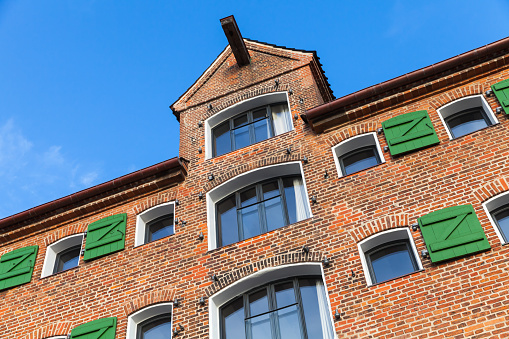 Old house facade, red brick wall with windows and crane beam. Copenhagen, Denmark