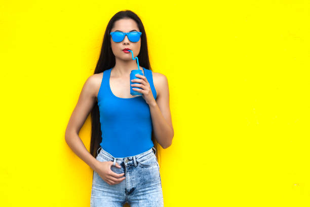 istock Woman with blue sunglasses drinking from blue can 898049804