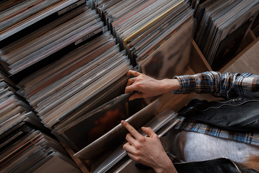 beautiful young woman audiophile is browsing vinyl records in a store