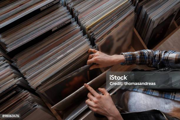 Beautiful Young Woman Audiophile Is Browsing Vinyl Records In A Store Stock Photo - Download Image Now