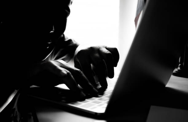 istock Hackers with black mask using hands of anonymous typing code on keyboard of laptop for remotely reach and receiving personal information online networking, Internet Crime Payment Security Concept 898065952