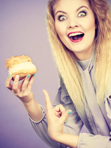 istock Funny woman holds cream puff cake 898066100