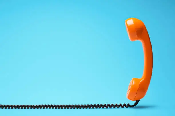 Photo of Telephone in retro style on blue background.