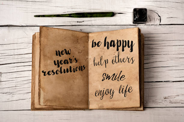 new years resolutions in a yellowish notebook - idealist imagens e fotografias de stock