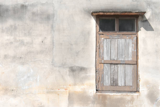 istock Old grunge wooden window isolated on cement wall 898070154