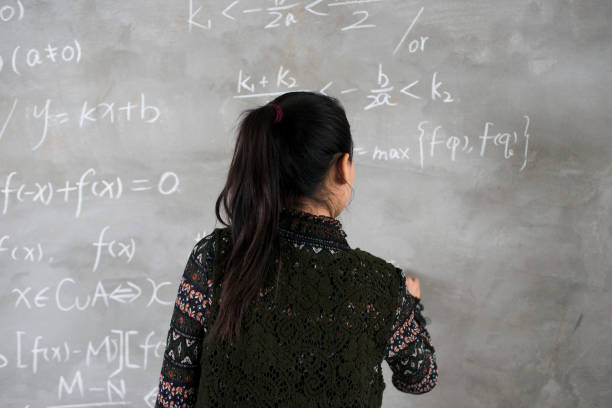 istock Female college students stand in front of the blackboard writing 898071108