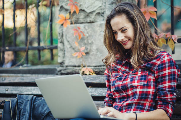 istock Woman smiling and texting on her laptop 898073240