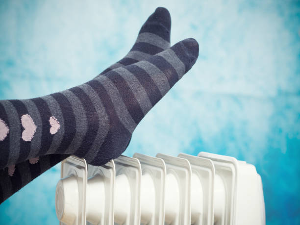 istock Female feet above the heater. 898073302