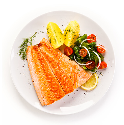 Fish dish - grilled salmon and vegetables on white background