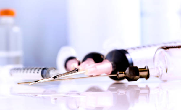 istock Medical syringes and injection vial on the white table. 898091730