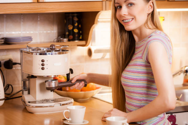 istock Woman in kitchen making coffee from machine 898102534