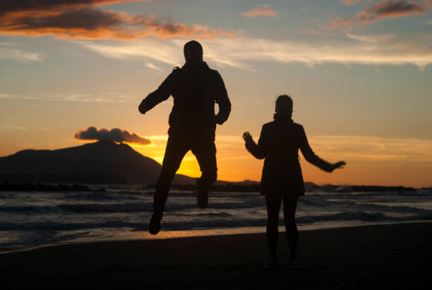 Couple in a sunset time Couple enjoying the sunset on the beach naples beach stock pictures, royalty-free photos & images